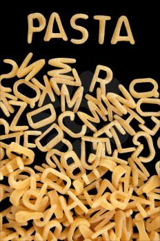Spelling of the word pasta with alphabet soup letters. Kids food background.