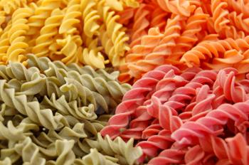 Four flavors of fusilli pasta. Italian food background.