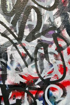 Metal surface covered with layers of messy graffiti and tags.