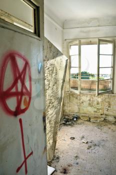 Satanic symbols graffiti on the door of an abandoned house.