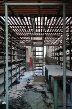 Empty shelves in abandoned vinyl records pressing factory storage room.