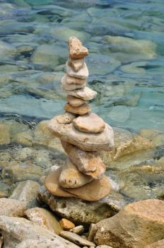 Balanced stone structure on rocky shore. Rock pile by the sea water.
