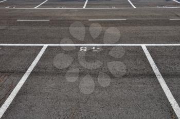 Dividing lines in empty asphalt paved parking lot abstract background.