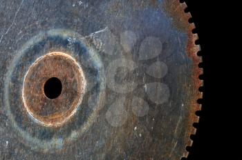 Rusty saw blade cutting wheel. Vintage industrial equipment on black background.