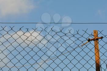 Chain link fence and blue sky urban background.