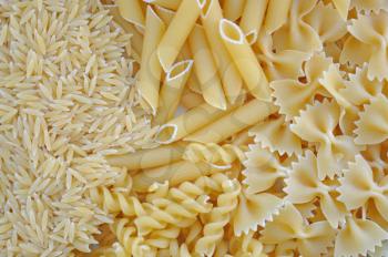 Risoni, penne, farfalle and fusilli. Italian cuisine pasta food varieties background.