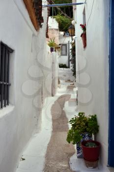 White painted narrow street and small houses in the traditional Anafiotika neighborhood of Plaka. Cycladic islands style architecture in the city of Athens, Greece.