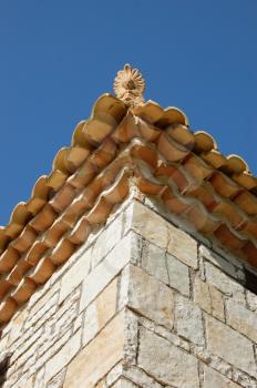 Ceramic antefix decorative pottery ornament on the roof of a house in Greece. Architectural detail.