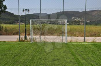 Soccer goalpost and net in empty sports field.