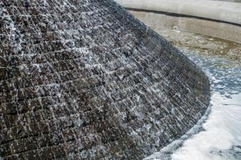 A closeup shot of water flowing down a fountain.