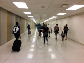 Airport exit tunnel with passengers blurred walking on shiny white floor