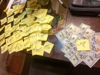many post it notes on table with pile of american cash