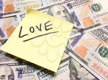 American cash money and yellow post it note with text Love in black color aerial view
