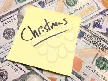 American cash money and yellow post it note with text Christmas in black color aerial view