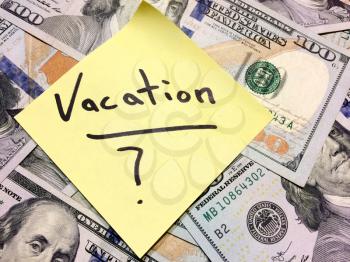 American cash money and yellow paper note with text Vacation with question mark in black color aerial view