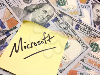American cash money and yellow sticky note with text Microsoft in black color aerial view