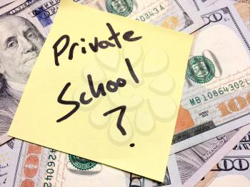 American cash money and yellow sticky note with text Private school with question mark in black color aerial view