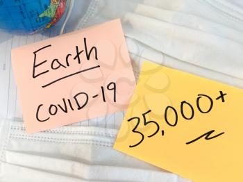 Coronavirus COVID-19 infection medical cases and deaths on Earth. China COVID respiratory disease influenza virus statistics hand written on surgical mask and earth globe background