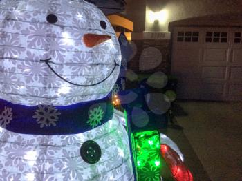 snowman christmas decoration with lights in yard at night time