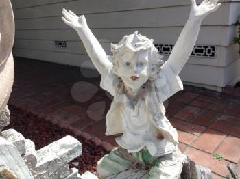 boy child garden statue smiling white concrete outdoor on a sunny day