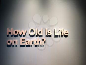 How old is the earth sign on grey wall