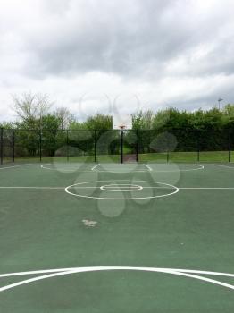 basketball court outside empty in park with sky clouds