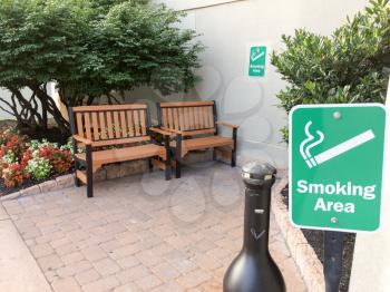 Outddor smoking area designated with benches and flower bed