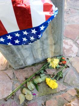 911 9-11 september terrorist attack memorial steel gurder and flag of deflated balloon and dead flowers concept