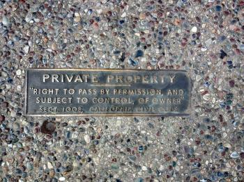Private property metal plate on sidewalk concrete stones