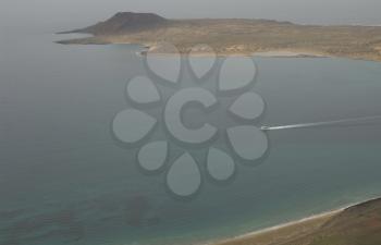 Ship sailing between El Risco beach and La Graciosa Island. Haria. Lanzarote. Canary Islands. Spain.