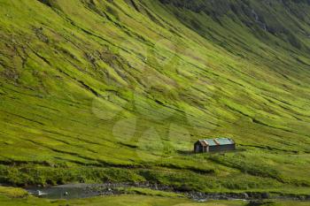 Living on Faroe Islands showing a farm surrounded by green mountains