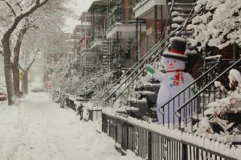 Sidewalk full of snow and smiling snowman during the first snowstorm  of 2014-15 in Montreal, Canada.