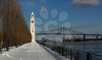 Clock tower and Jacques Cartier bridge during winter in the old port, Montreal