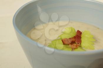 Close up of a potato soup in a pale blue bowl.