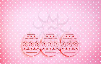 Decorated felt easter eggs pink on a pinky polka dots background