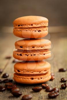 Row of coffee macarons on a table with coffee beans