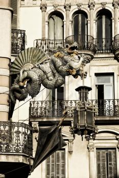 Dragon holding a lantern on a building on the rambles in Barcelona.