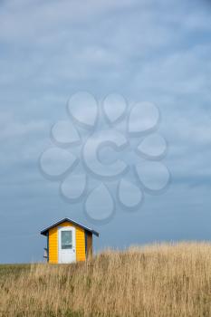 nice little yellow house in a middle of a field in Magdalen island in Canada.  Image taken from the street.