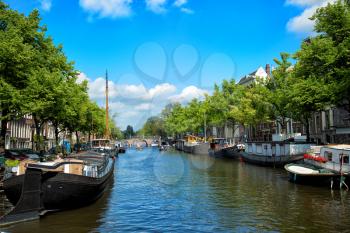 The famous canals and embankments with boats of Amsterdam city.