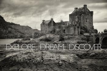 inspirational quote saying Explore, dream, discover on Eilean Donan Castle in black and white at low tide in the Highlands, Scotland