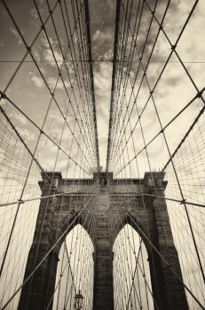 Brooklyn bridge in New York is one of the oldest bridges of either type in the United States. Completed in 1883.  Picture in sepia