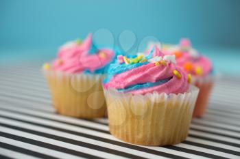 Cupcakes with blue and pink icing on a black and white lined background
