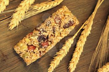 Top view of a granola bar with honey, almond, nuts, raisin and wheat on a wooden table