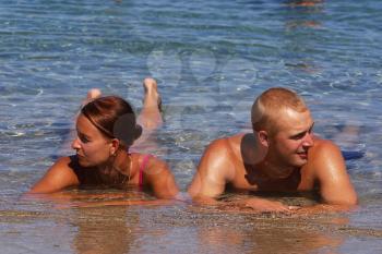 Royalty Free Photo of a Couple Laying in Water Talking