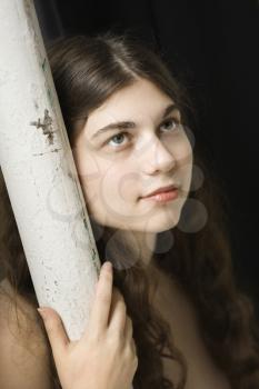 Royalty Free Photo of a Woman Leaning Against a Pole 