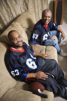 Royalty Free Photo of a Father and Son Wearing Matching Football Jerseys 