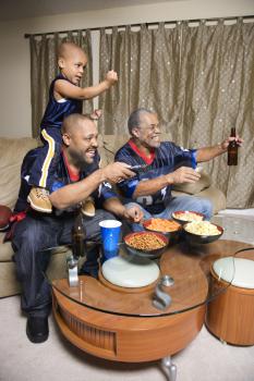 Royalty Free Photo of a Family Watching a Football Game on Television