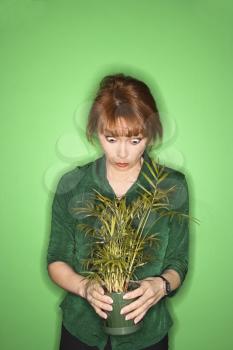 Royalty Free Photo of a Woman Holding a Plant