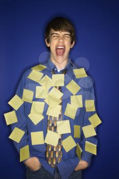 Royalty Free Photo of a Teen Boy Covered With Sticky Notes and Screaming