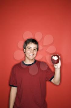 Royalty Free Photo of a smiling teen boy holding partially eaten apple